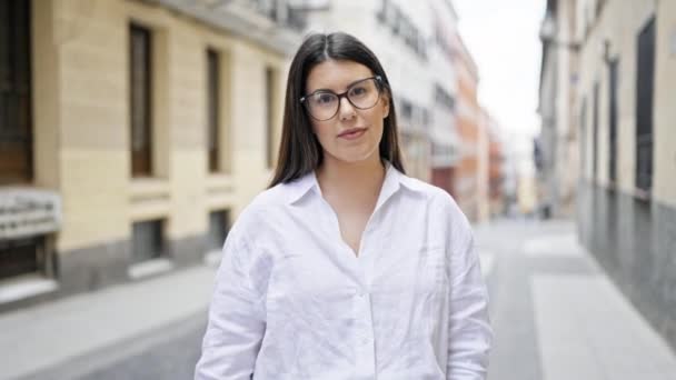 在马德里的大街上 年轻美丽的惊慌失措的女人戴着眼镜 高兴地交叉着双臂 — 图库视频影像