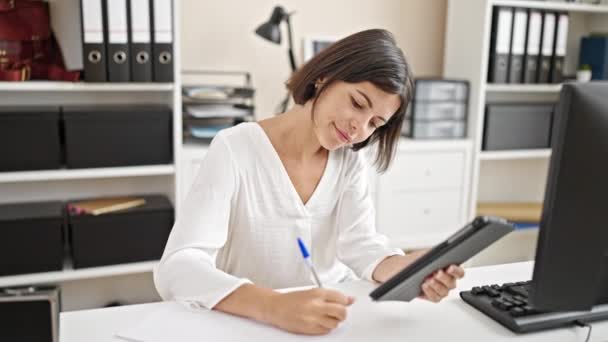 Young Beautiful Hispanic Woman Business Worker Using Touchpad Writing Document — Stockvideo