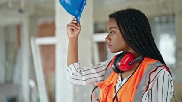 非洲裔美国女建筑工人站在建筑工地 头戴硬礼帽 表情轻松 — 图库视频影像