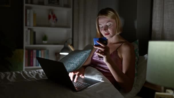 Laptop Kredi Kartıyla Alışveriş Yapan Genç Sarışın Kadın Yatak Odasında — Stok video