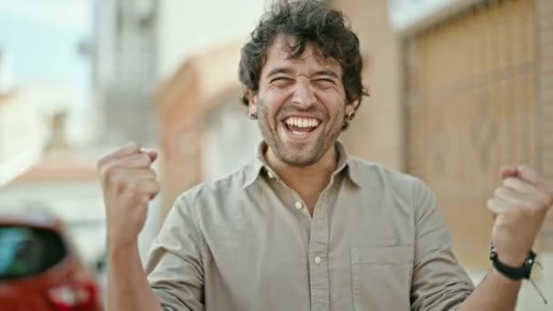 Ung Latinamerikansk Man Ler Säker Stående Med Vinnaren Gest Gatan — Stockvideo
