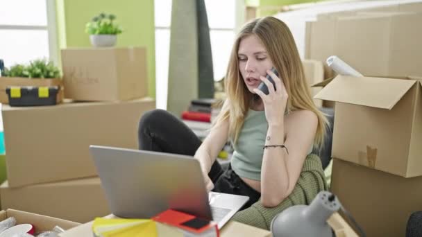 Junge Blonde Frau Telefoniert Neuen Zuhause Mit Laptop Auf Smartphone — Stockvideo
