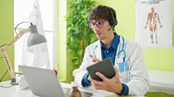 Jovem Médico Hispânico Fazendo Videochamada Com Laptop Escrevendo Touchpad Fazendo — Vídeo de Stock