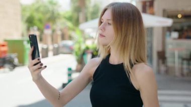 Genç sarışın kadın gülümsüyor. Kendine güveni tam.