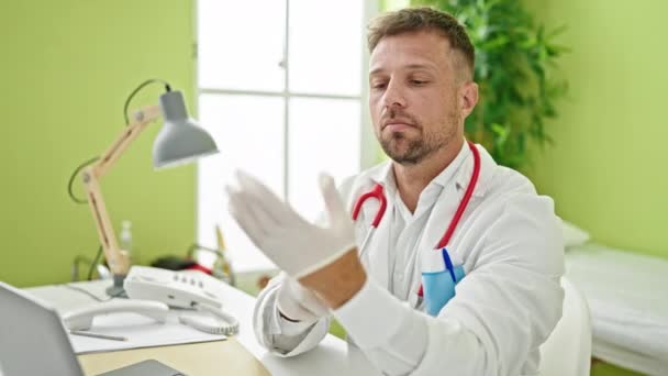 診療所で手袋を身に着けているラップトップを使用して若い男性医師 — ストック動画