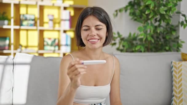 Junge Schöne Hispanische Frau Hält Schwangerschaftstest Mit Siegerausdruck Hause — Stockvideo