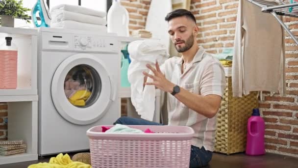 若いヒスパニック系の男洗濯室で服を洗う — ストック動画
