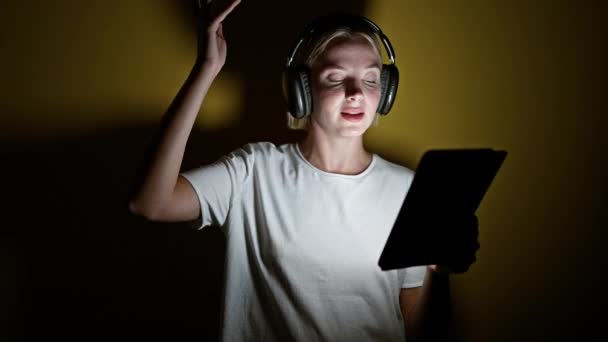 Νεαρή Ξανθιά Γυναίκα Χαμογελά Αυτοπεποίθηση Ακούγοντας Μουσική Χορεύει Απομονωμένο Κίτρινο — Αρχείο Βίντεο