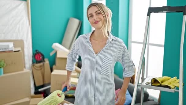 Young Blonde Woman Holding Paint Roller Smiling New Home — Stock Video