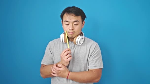 Φορώντας Ακουστικά Έχοντας Ιδέα Πάνω Από Απομονωμένο Μπλε Φόντο — Αρχείο Βίντεο