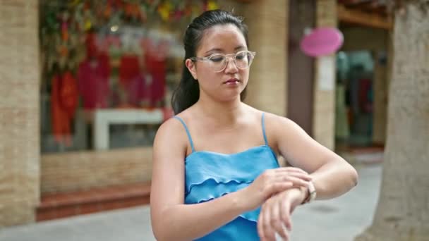 年轻的中国女人在街上严肃地看着表 — 图库视频影像
