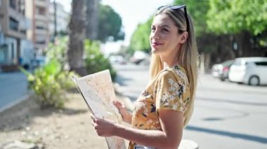 Genç sarışın kadın turist gülümsüyor. Kendine güvenen şehir haritası.