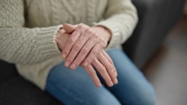 Olgun İspanyol kadın evde el kremi sürüyor.