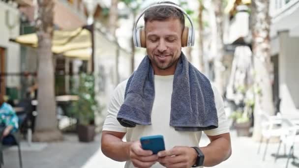 Junger Mann Sportkleidung Hört Musik Mit Smartphone Auf Der Straße — Stockvideo