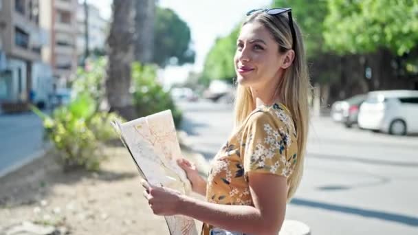 Νεαρή Ξανθιά Γυναίκα Τουρίστρια Χαμογελώντας Αυτοπεποίθηση Αναζητούν Χάρτη Της Πόλης — Αρχείο Βίντεο