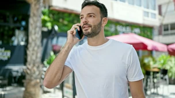 Ung Latinamerikansk Man Ler Säker Talar Smartphone Gatan — Stockvideo