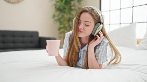 Jong Blond Vrouw Luisteren Naar Muziek Drinken Koffie Slaapkamer — Stockvideo