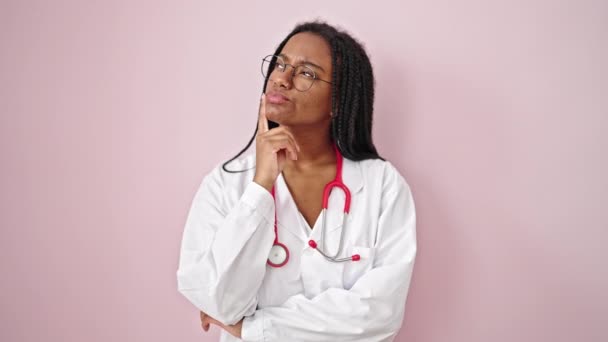 Αφροαμερικανίδα Γιατρός Στέκεται Αμφιβολία Σκέψης Έκφραση Πάνω Από Απομονωμένο Ροζ — Αρχείο Βίντεο