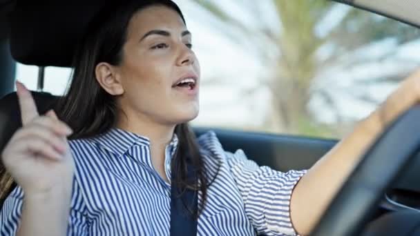 若い美しいヒスパニックの女性が車のダンスを運転し 道路で音楽を楽しむことに署名 — ストック動画