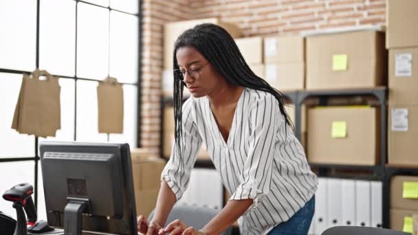 アフリカ系アメリカ人女性Eコマースビジネスワーカー オフィスでコンピュータを保持するパッケージを使用して — ストック動画