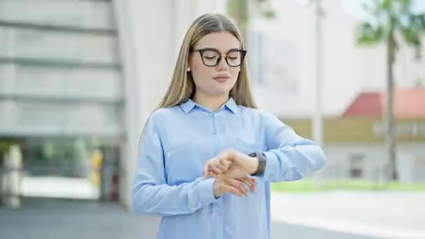 Joven Mujer Rubia Trabajadora Negocios Pie Con Expresión Seria Mirando — Vídeo de stock