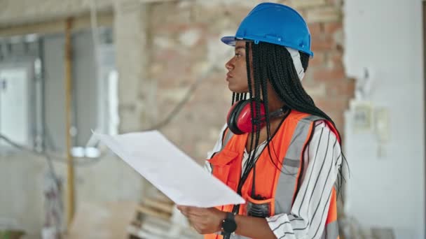 在建筑工地用对讲机交谈的非裔美国女建筑工人读房项目 — 图库视频影像