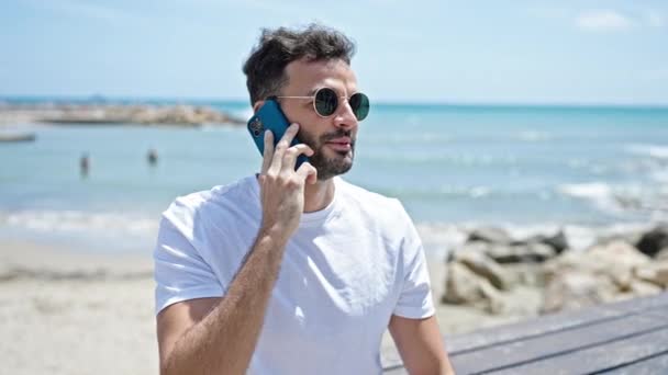 Jonge Spaanse Man Glimlacht Vol Vertrouwen Praten Smartphone Aan Zee — Stockvideo