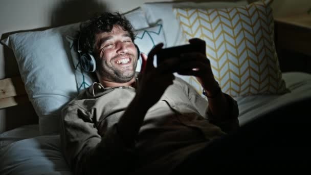 Genç Spanyol Adam Yatakta Uzanmış Akıllı Telefondan Video Izliyor — Stok video