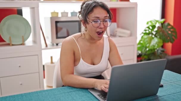 若い美しいヒスパニック女性は ダイニングルームでノートパソコンのヨーイングを使用して疲れました — ストック動画