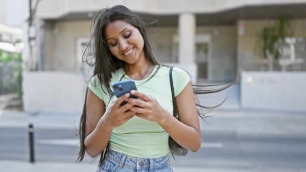 ストリートで祝うスマートフォンを使用する若いラテン系女性 — ストック動画