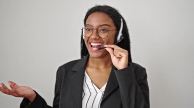 Afro-Amerikalı kadın çağrı merkezi ajanı gülerek izole edilmiş beyaz arka planda konuşuyor.