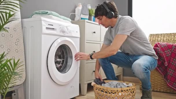 在洗衣房听音乐洗衣服的年轻人 — 图库视频影像