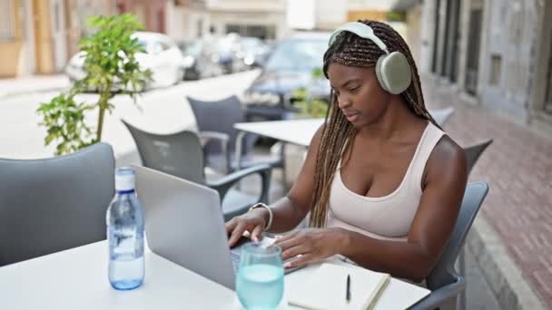 Mujer Afroamericana Bebiendo Vaso Agua Estudiando Terraza Cafetería — Vídeos de Stock