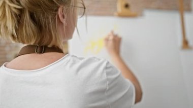 Sanat stüdyosunda çizim yapan genç sarışın kadın.