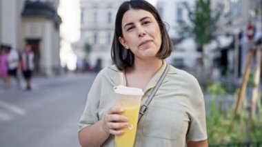 Genç ve güzel İspanyol kadın Viyana sokaklarında köpüklü çay içiyor.