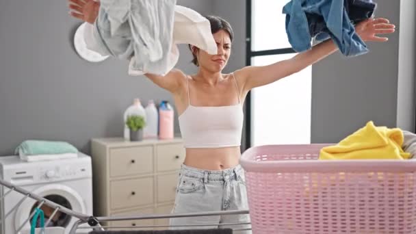 年轻美丽的惊慌失措的女人强调要把衣服扔到洗衣房 — 图库视频影像