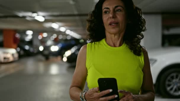 Mulher Hispânica Meia Idade Usando Smartphone Sorrindo Estacionamento — Vídeo de Stock