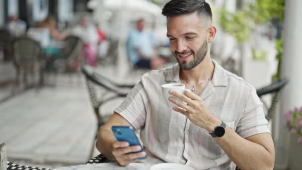 Joven Hispano Usando Smartphone Bebiendo Café Terraza Cafetería — Vídeo de stock