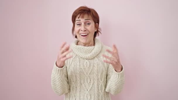 Зріла Іспаномовна Жінка Посміхається Танцює Над Ізольованим Рожевим Тлом — стокове відео