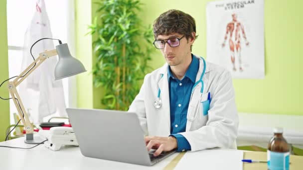 Jovem Hispânico Homem Médico Usando Laptop Estressado Clínica — Vídeo de Stock