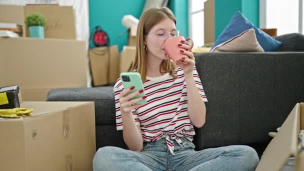 Mujer Rubia Joven Usando Smartphone Bebiendo Café Casa Nueva — Vídeo de stock