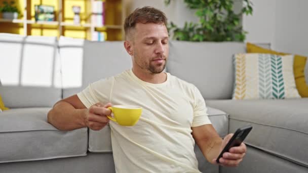 Genç Adam Akıllı Telefon Kullanıyor Kahve Içiyor Evde Gülümsüyor — Stok video