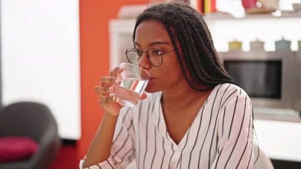 アフリカ系アメリカ人女性は ダイニングルームで歯痛のためにテーブルの上に座って水を飲む — ストック動画