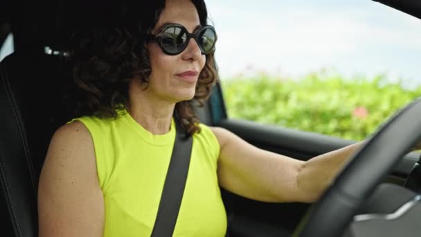 Mulher Hispânica Meia Idade Dirigindo Carro Sorrindo Usando Óculos Sol — Vídeo de Stock
