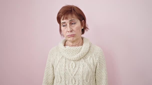 Ältere Hispanische Frau Steht Mit Langweiligem Gesichtsausdruck Vor Isoliertem Rosa — Stockvideo