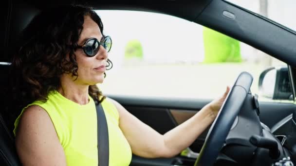 Μεσήλικας Ισπανίδα Που Οδηγεί Ένα Αυτοκίνητο Χαμογελώντας Φορώντας Γυαλιά Ηλίου — Αρχείο Βίντεο