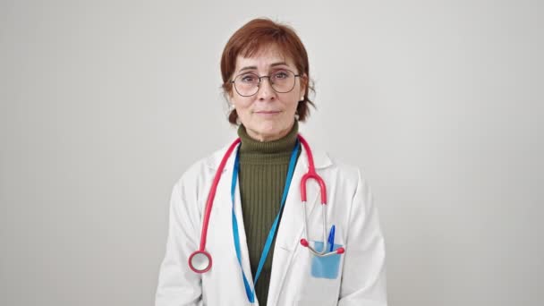 成熟したヒスパニックの女性医師は 孤立した白い背景の上に胸に手で誓う — ストック動画