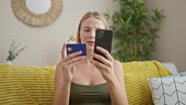 Ung Blond Kvinna Shopping Med Smartphone Och Kreditkort Sitter Soffan — Stockvideo