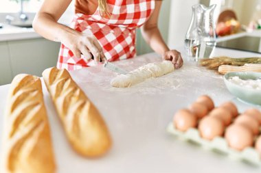 Genç ve güzel İspanyol kadın mutfakta ekmek yapıyor.