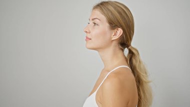 İzole edilmiş beyaz arka planda ciddi bir yüzü olan genç sarışın kadın.